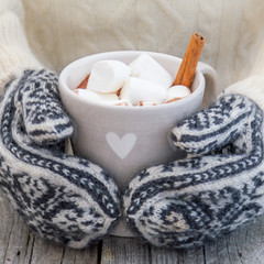 Hands in mittens holding hot chocolate