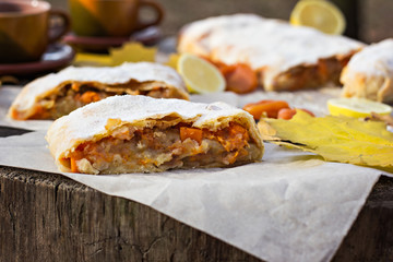 Strudel with apples, pumpkin, apricots, lemon. Autumn table decoration