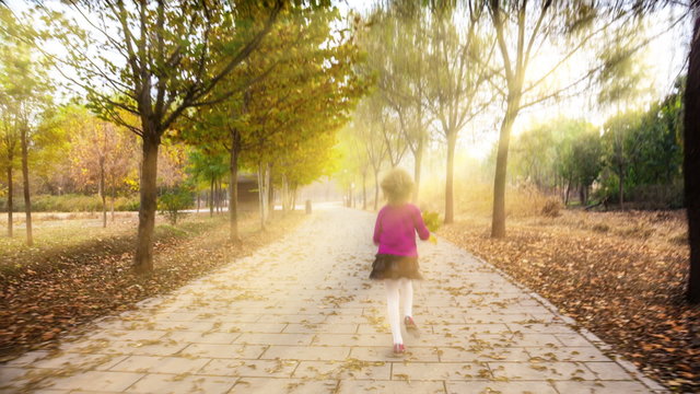 Cute girl walk in the rays of the autumn sun.