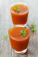 Fresh carrot juice in glass on wooden table, healthy vegetable drink