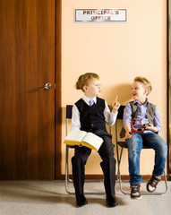 Schoolboys are sitting beside the principal's office