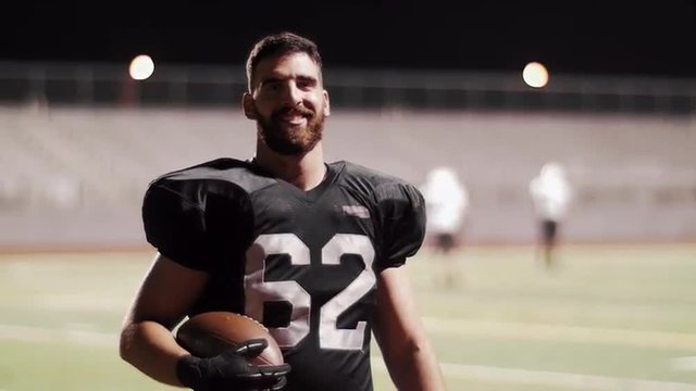 Portrait of a football player on the field at night
