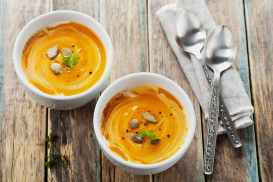 Fresh carrot soup in white bowl, dietary vegetable soup, rustic style