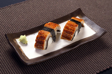 Anago sushi with wasabi on ceramic dish, boiled eel with sushi r