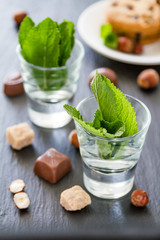 Mint in glass cups, chocolate, nuts
