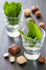 Mint in glass cups, chocolate, nuts