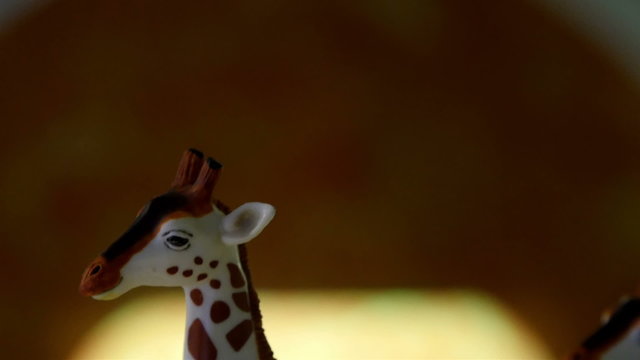 A figure of a giraffe on display. A small toy-like figure of a giraffe that is not moving