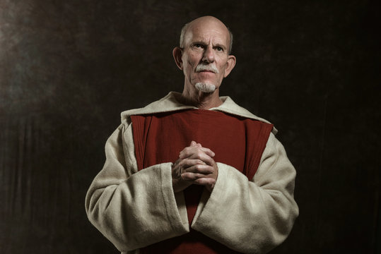 Official portrait of monastic. Studio shot against dark wall.