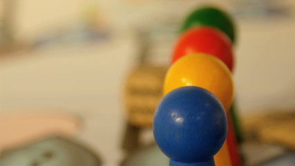 Closer look of the colorful wooden pins. Blue yellow red and green pins are used for a game with dice