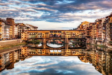 Ponte Vecchio bridge in Florence, Italy. Arno River under romantic sky