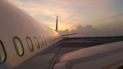 airplane wing and tail with the sunset