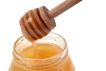 Cuillère à miel trempée dans un pot de miel