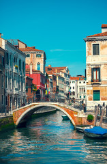Fototapeta na wymiar Bridge over channel among houses in Venice Italy