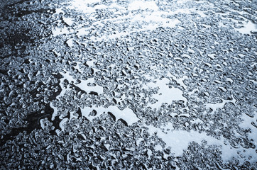 Water drops on wet dark asphalt, blue toned