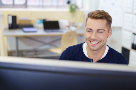l&auml;chelnder gesch&auml;ftsmann schaut auf computer