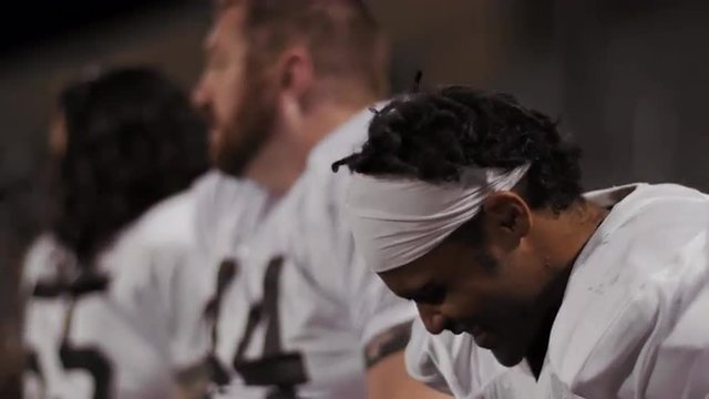 Football players watching their team from the sidelines
