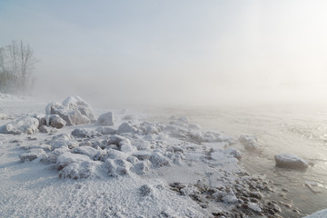 Stones and river covered with frost and snow