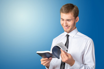 Handsome young business man reading a book