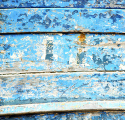 Fototapeta na wymiar stripped paint in the blue wood door and rusty nail