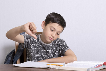 Young Boy Giving Thumbs Down Over Homework