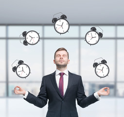 Meditative businessman is pondering about time management in the modern panoramic office. The...