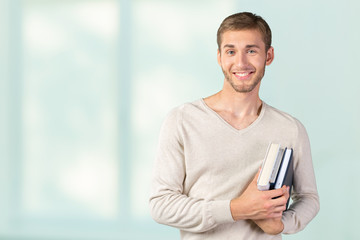 Handsome young man holding books