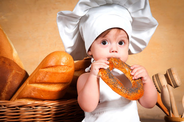 Little cook with a bagel in her hands.