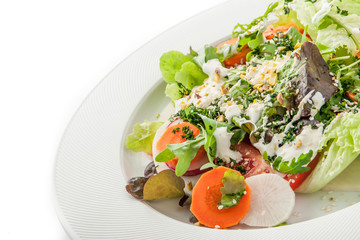 Vegetable salad with greens and sesame on the white plate