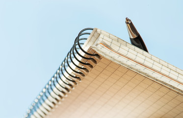 Obraz premium blank notebook with pen on a sky background