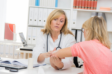 patientin zeigt ihrer ärztin den arm