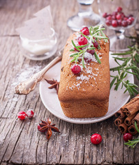 Homemade cupcake cake with cranberries and rosemary on a wooden background