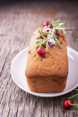 Homemade cupcake cake with cranberries and rosemary on a wooden background