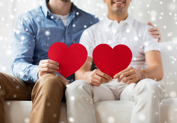 close up of happy gay male couple with red hearts