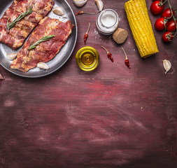 border Ingredients for cooking raw Meat with bones for soup or broth with with herbs, cherry tomatoes, oil, corn, spices on wooden rustic background top view place for text,frame