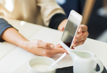 close up of women with smartphone at restaurant