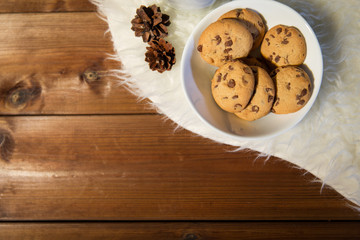 close up of cookies in bowl and cones on fur rug