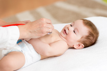 Obraz na płótnie Canvas doctor examining baby with stethoscope