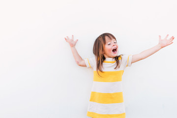 Young girl in a striped dress performing and singing with her arms outstretched