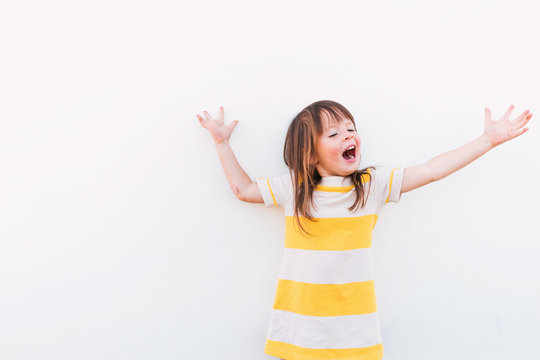 Young girl in a striped dress performing and singing with her arms outstretched