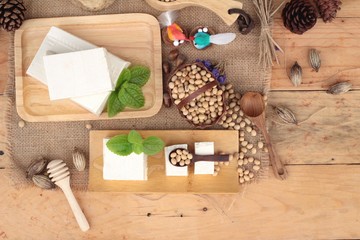 Tofu and soybeans on wood background.