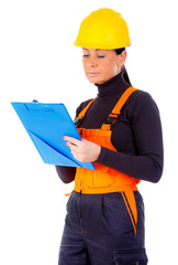 Close Up portrait attractive woman builder with notepad in hand, looking to notepad and write, yellow helmet and working overalls, concentrate on the job, makes decision, isolated white background.