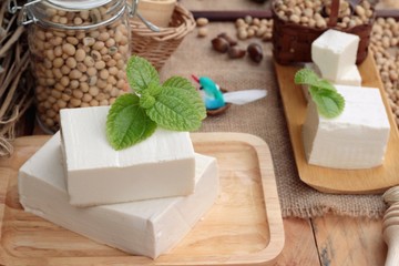 Tofu and soybeans on wood background.