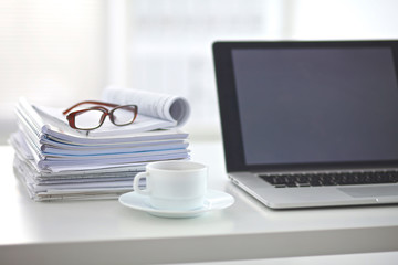 Obraz na płótnie Canvas Laptop with stack of folders on table on white background