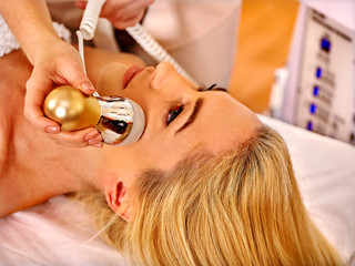 Fototapeta premium Young woman receiving electric facial massage.
