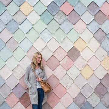 Woman standing next to a colorful wall