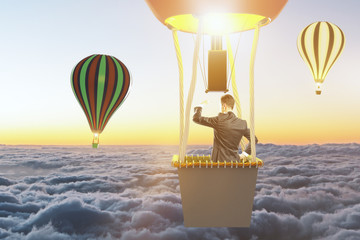 Businessman flying on a balloon and looks at the horizon