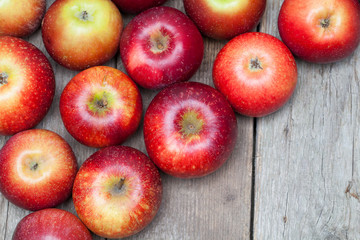 Red apples on wooden board.