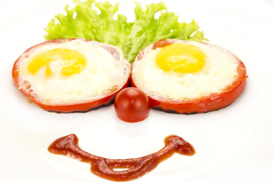 eggs as a smiley face adorned with greenery on a white plate
