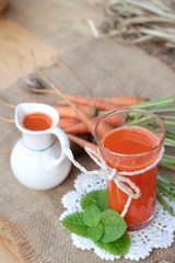Fresh squeezed carrot juice and fresh carrots.