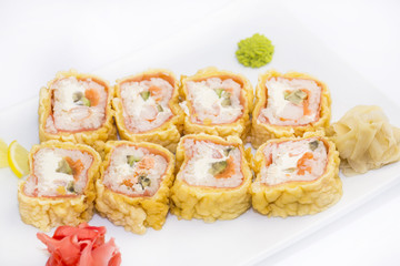 plate of sushi beautifully decorated with salad and fruit on a white background
